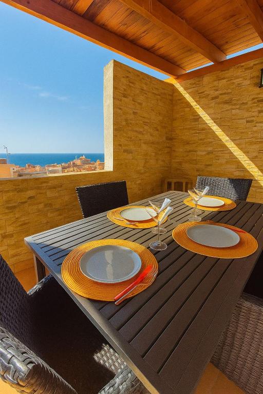 a dining table with plates and chairs on a patio at Palma79-Kira in Águilas