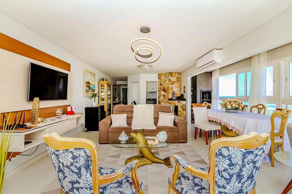 a living room with a couch and a table at Mar a Lago - Beira Mar Barra Velha - 4 Quartos in Barra Velha