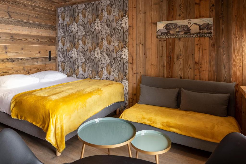 a bedroom with two beds and a table and chairs at Résidence GRAND COCOR, Skis aux pieds -Studio 25 m2- by MONTBLANC LOGDE in Val dʼIsère