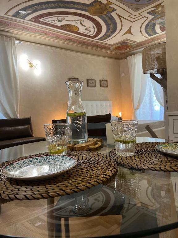 a table with glasses and a vase on top of it at FresCo b&b in Sarnico