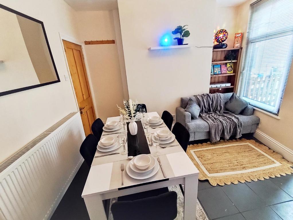 a living room with a table and a couch at Peak District Cottage Sleeps 6, Parking and Projectors in all the Rooms in Buxton