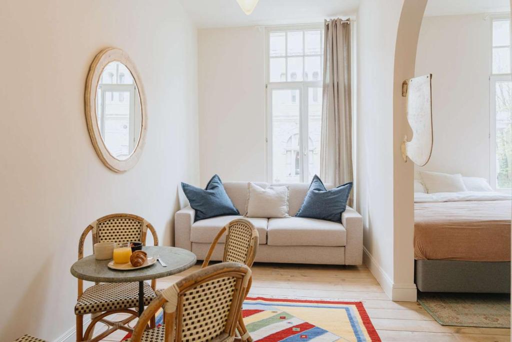 a living room with a couch and a table and chairs at Urban Hideout Just Steps from Antwerp's Highlights in Antwerp