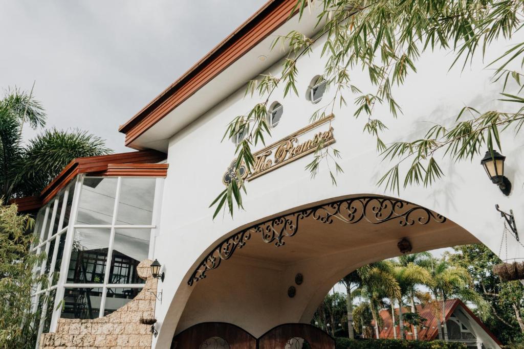 ein weißes Gebäude mit einem Torbogen davor in der Unterkunft The Premises Hotel in Dipolog City