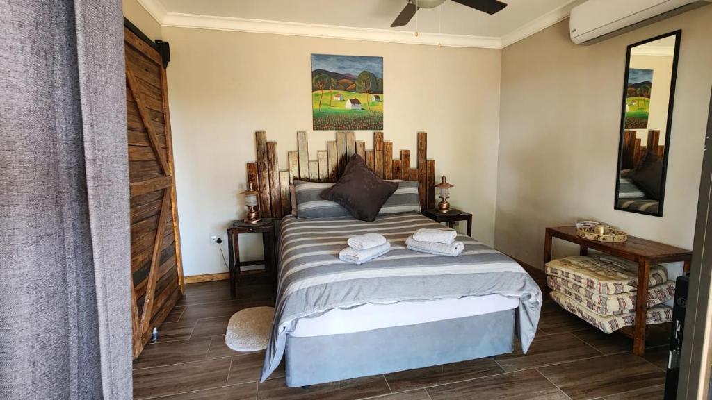 a bedroom with a bed with two towels on it at Berlouri Guest House Family Suite in Hekpoort