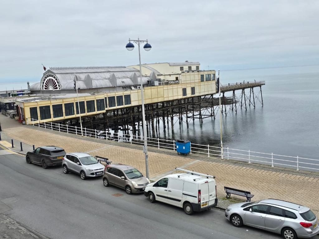 a pier with cars parked in front of the water at Seaview Apartment in Aberystwyth