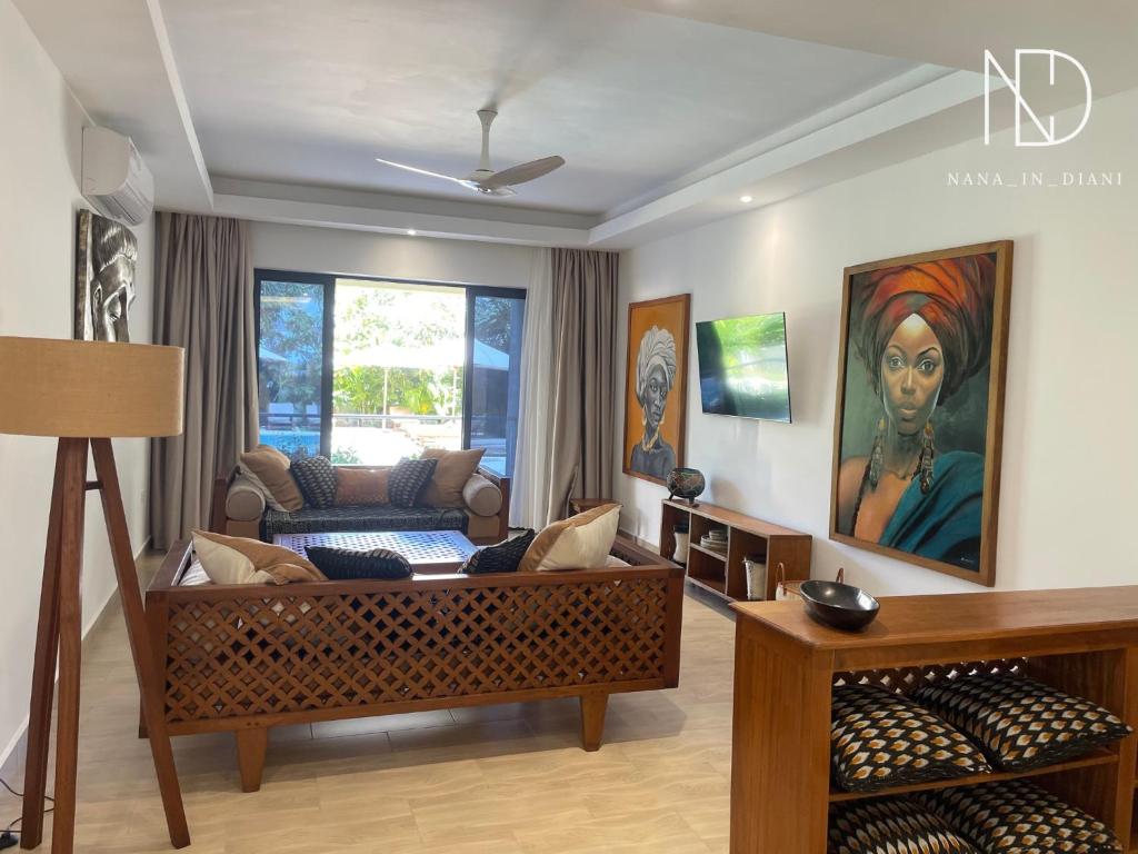 Una sala de estar con un sofá y un cuadro en la pared. en beachfront hideaway 1bed with pool&ac, en Diani Beach