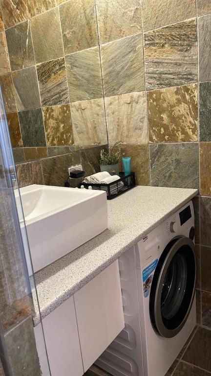 a bathroom with a washing machine and a sink at Ferielejlighed IRIS in Sønderborg