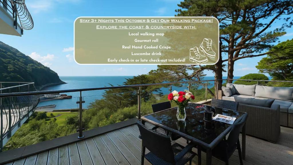 a balcony with a table with a vase of flowers on it at Ocean Terrace, Luxury Family Apt, Sea view and Terrace, 2 BR, Parking in Lynmouth