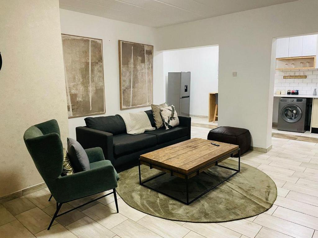 a living room with a couch and a table and chairs at Canvas Lofts 1 – Famona modern 2-bed - 2310 in Bulawayo