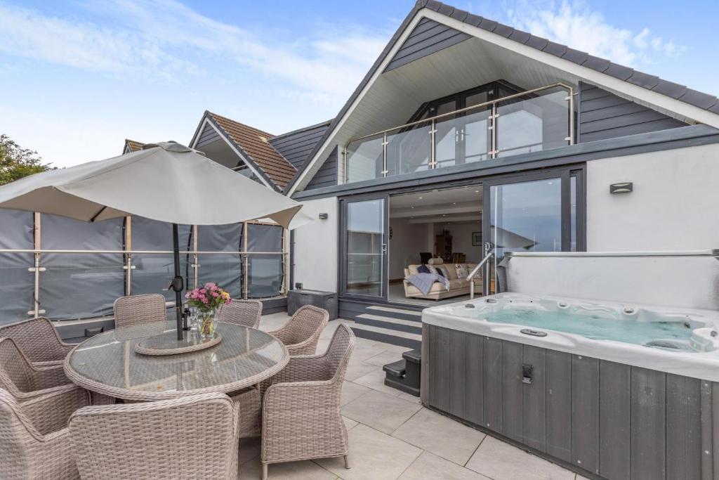 een huis met een hot tub en een tafel en stoelen bij 4 Bed in Woolacombe oc-l33535 in Mortehoe
