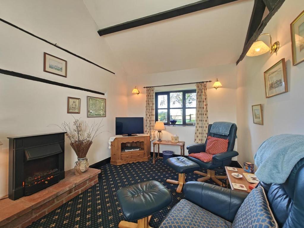 uma sala de estar com um sofá e cadeiras e uma lareira em 1 Bed in Yaxham oc-w33631 em Yaxham