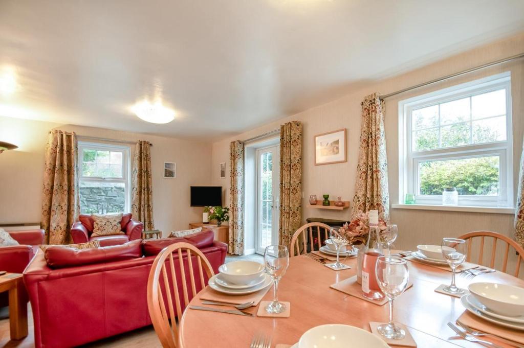 een eetkamer met een tafel en een rode bank bij 2 Bed in Broad Haven oc-h33632 in Broad Haven