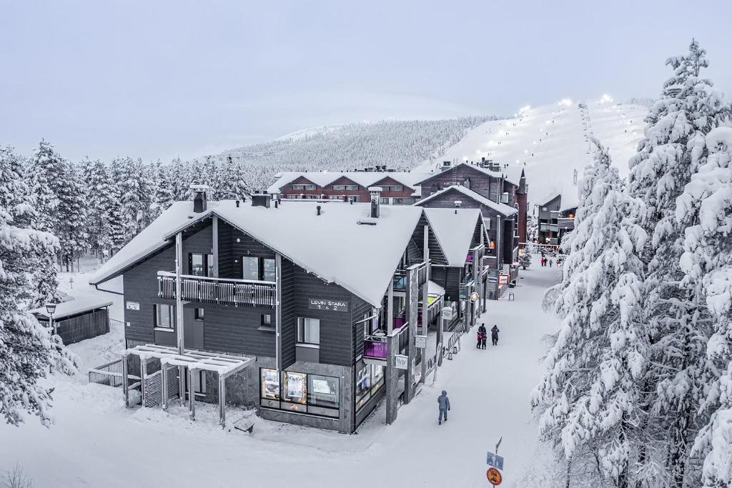 レヴィにあるLevin Stara A6 Visit Leviのロッジの隣の雪の中を歩く人々のグループ