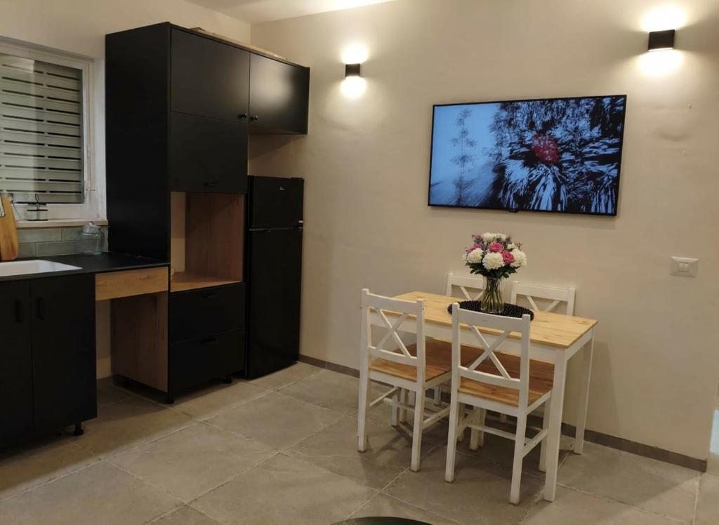 Gonenにあるשלווה בנוף העמקのキッチン(テーブル、椅子、壁掛けテレビ付)