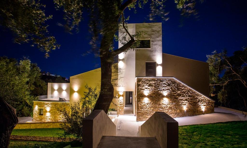 a house with lights on the side of it at Golden Bay Suites & Maisonettes in Parga