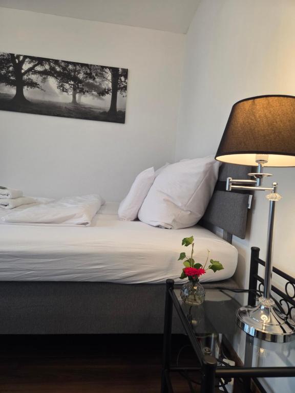 a bedroom with a bed with a lamp and a table at Gasthaus Löwen in Tisis in Feldkirch