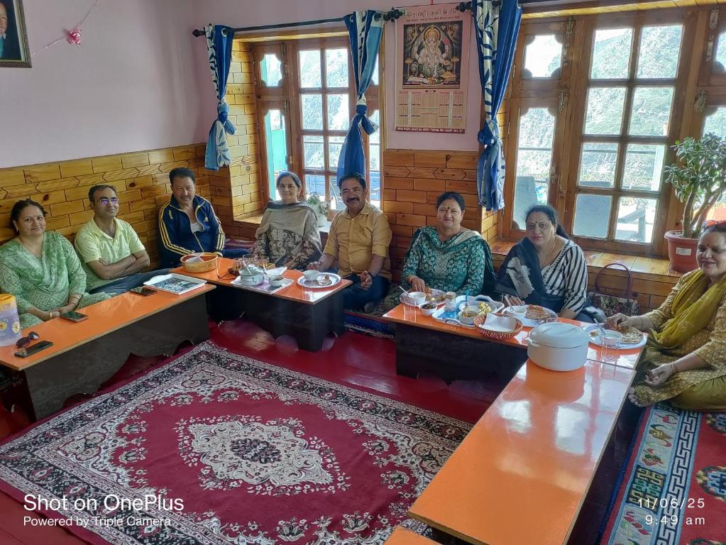 a group of people sitting at tables in a room at Shugu a village home stay in Gondla