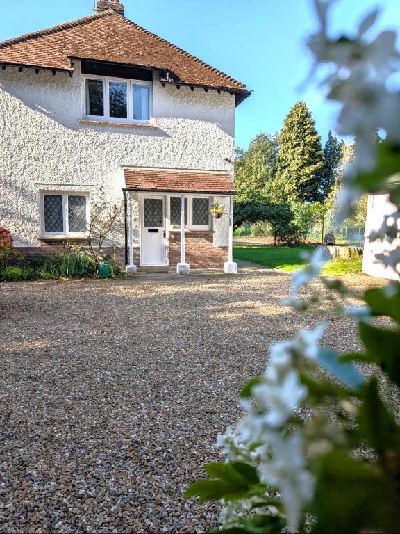 Hotel Cosy Cottage with Large Garden I Semi Rural Retreat! Nearby Countryside, Beaches & Goodwood - Chichester Holiday Properties, a house with a gravel driveway in front of it at Cosy Cottage with Large Garden I Semi Rural Retreat! Nearby Countryside, Beaches & Goodwood - Chichester Holiday Properties in Eartham