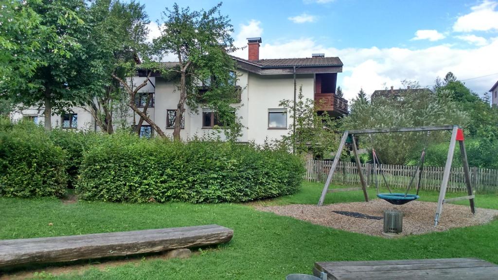 un patio con parque infantil frente a una casa en Haus Ruf en Windischgarsten