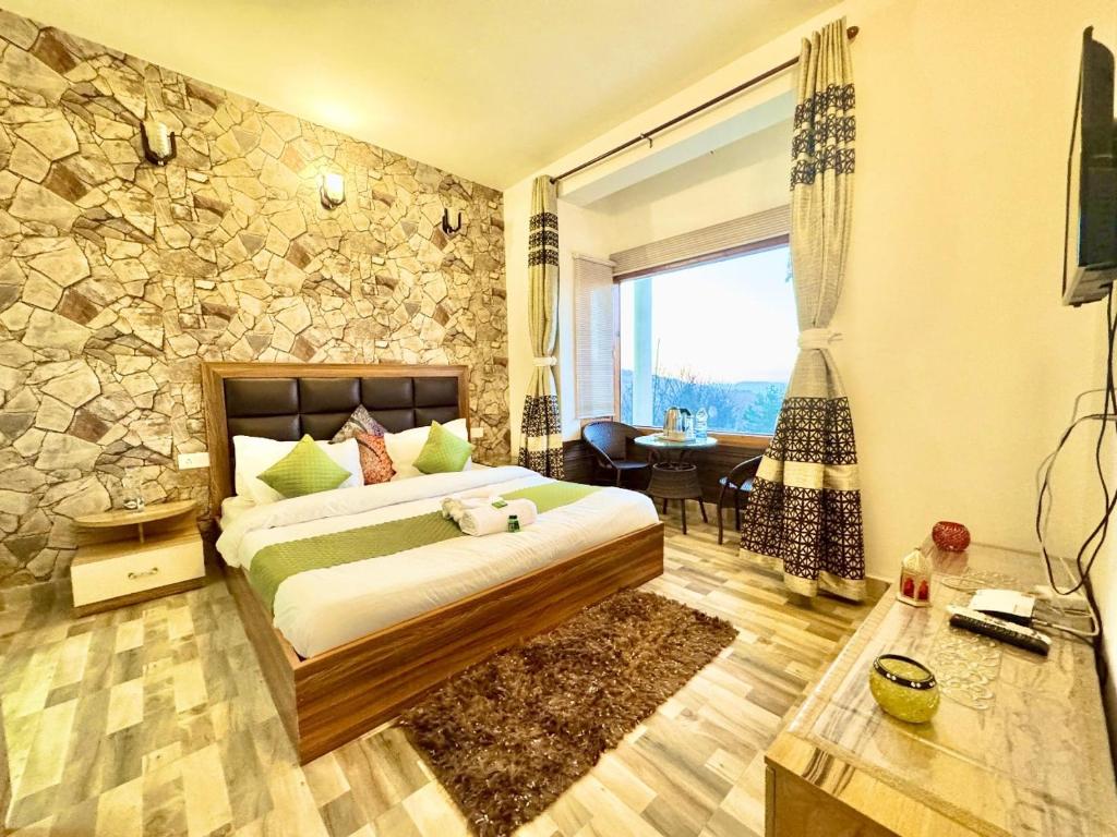 a bedroom with a bed and a stone wall at The Kufri Hills in Kūfrī