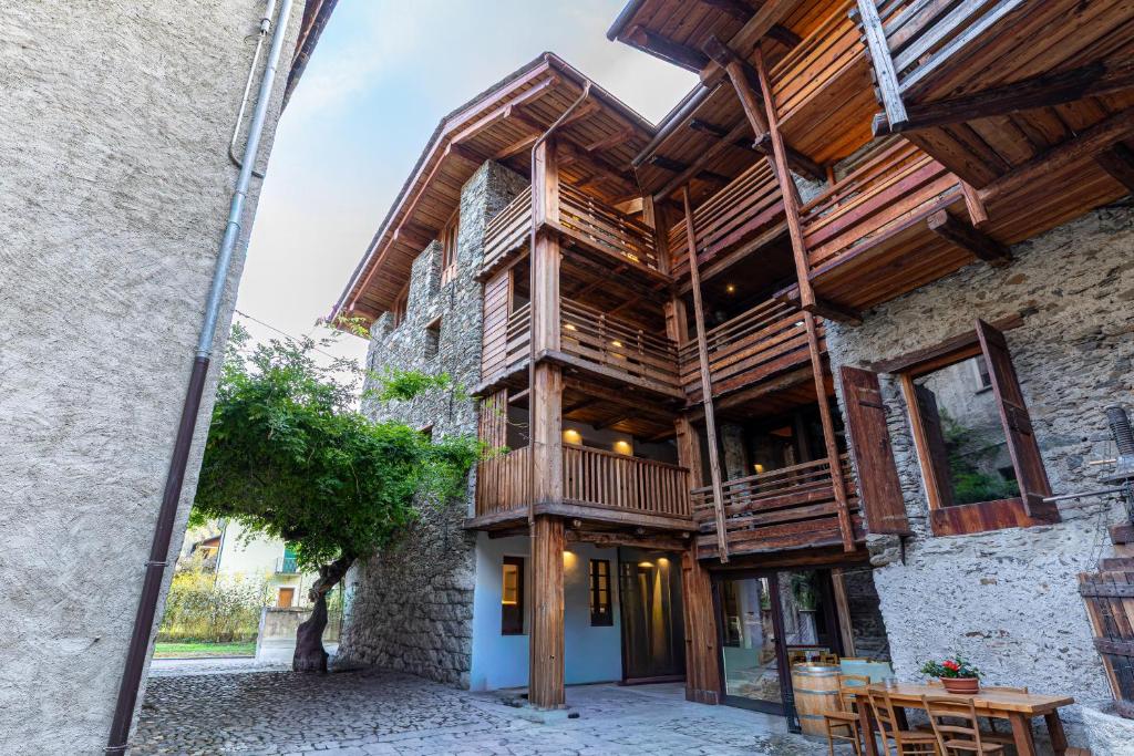 ein Holzhaus mit Balkon auf einem Gebäude in der Unterkunft La Corte del Glicine in Villa di Tirano