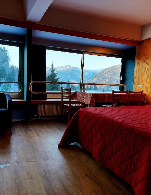 a bedroom with a bed and a view of mountains at Marilleva 1400 tra sport e natura in Marilleva