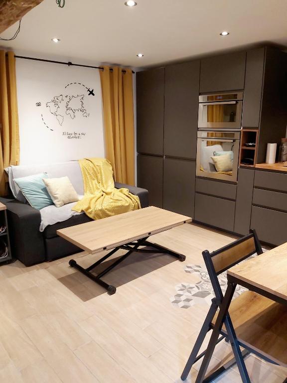 a living room with a couch and a table at Jolie maison Foix in Foix