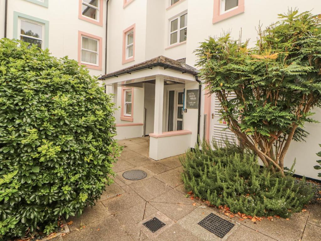 einen Eingang zu einem Gebäude mit zwei großen Büschen in der Unterkunft Flat 17 Greta Grove in Keswick