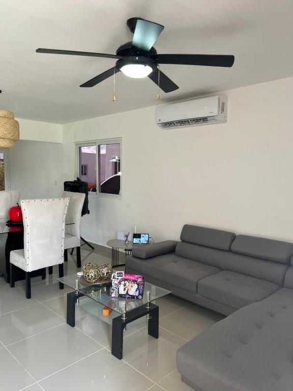 a living room with a couch and a ceiling fan at Paradise away from home in Punta Cana