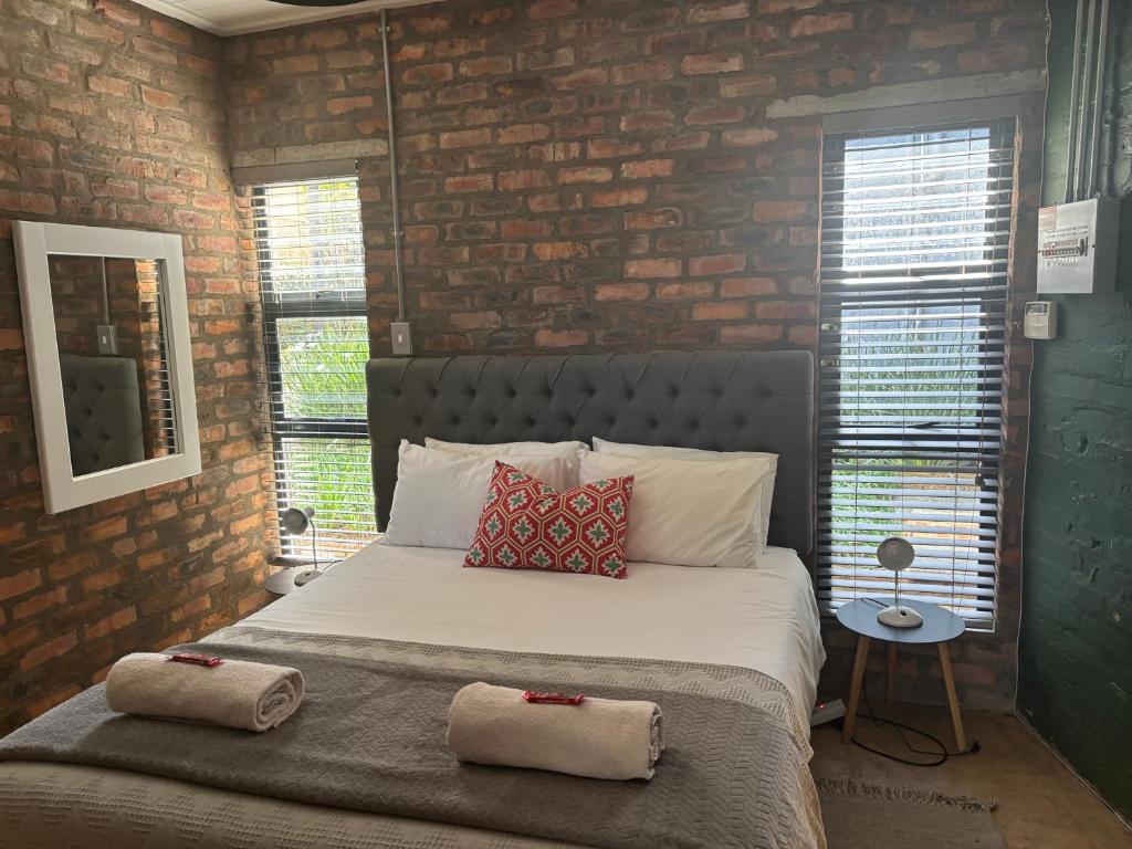 a bedroom with a bed with two pillows on it at Cottage on Salvia in East London