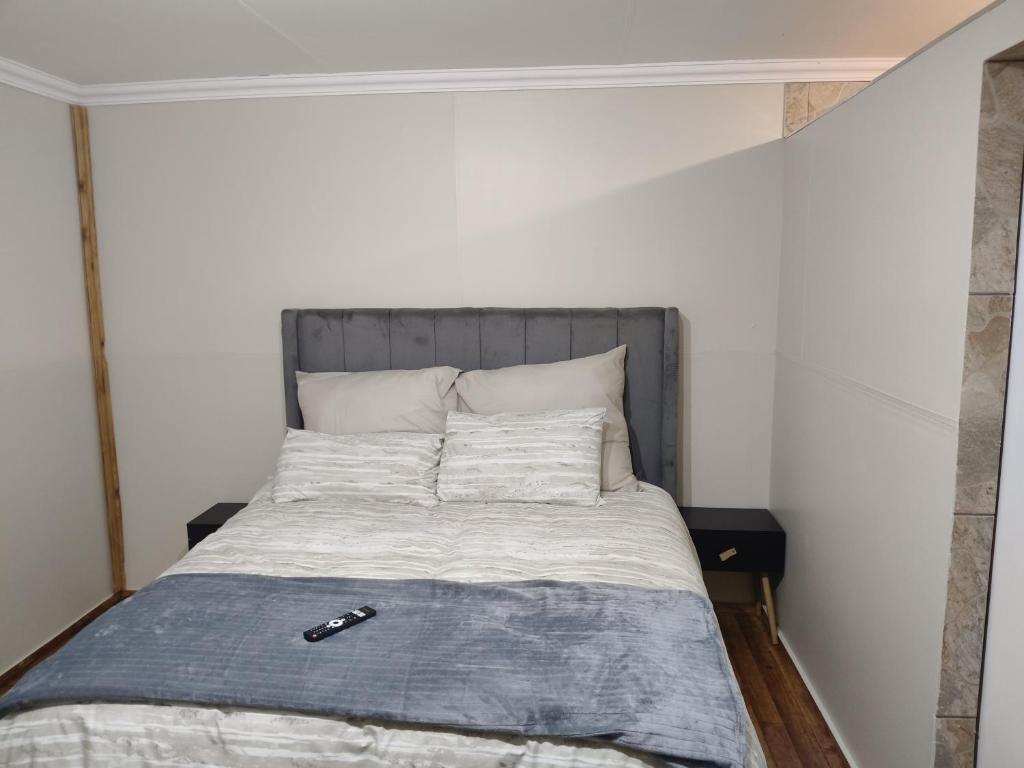 a bed in a room with a gray headboard at The Man Cave Extension in Sabie