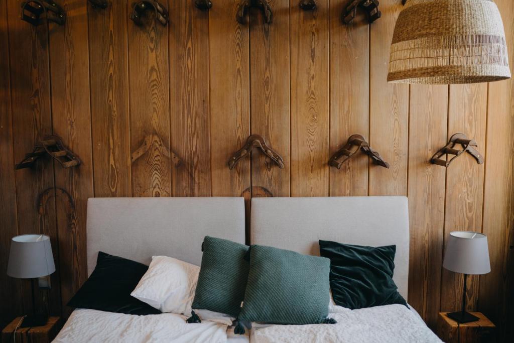 Un dormitorio con una cama con una pared de madera. en Folwark Wąsowo, en Wąsowo