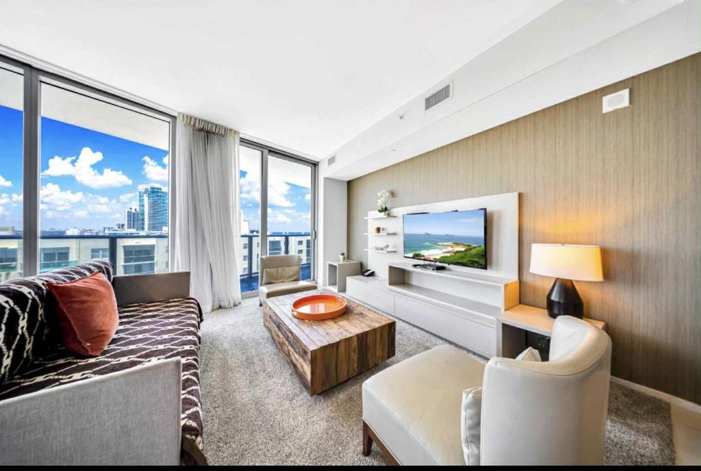 a living room with a couch and a tv at Beautiful Beach front condo with Top Amenities in Hollywood