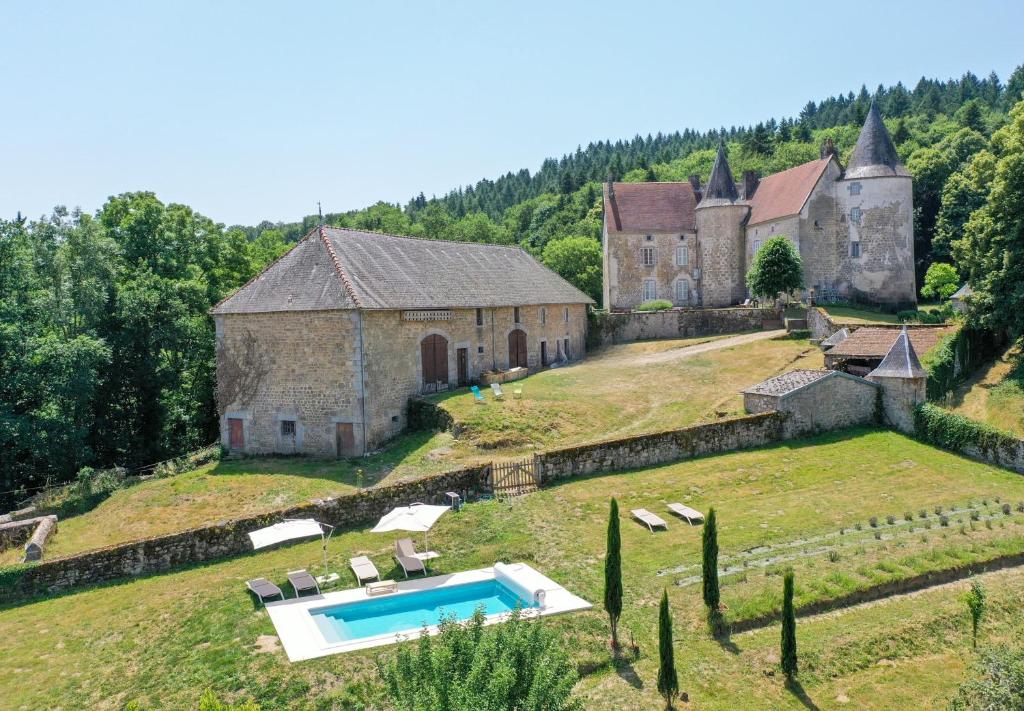 an old building with a swimming pool in front of it at Le Refuge de la Tardes in Champagnat