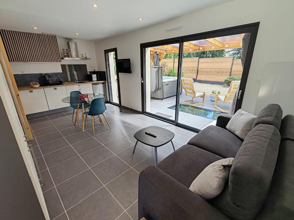 a living room with a couch and a kitchen at Appart'semaine in Cléguer