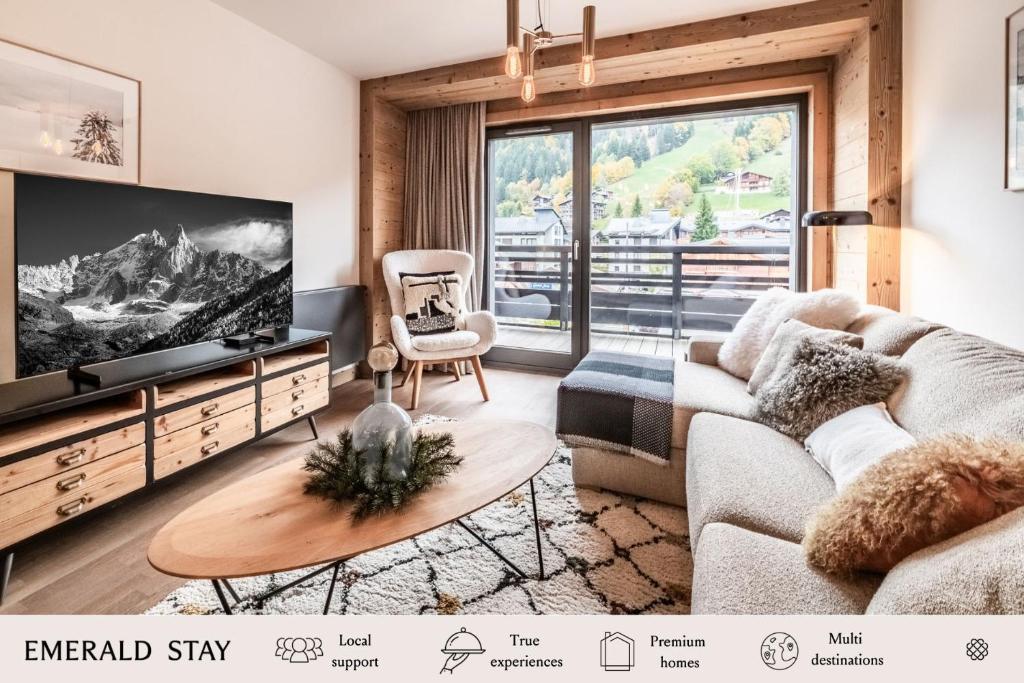 a living room with a couch and a tv at Apartment Alva Les Gets - by EMERALD STAY in Les Gets