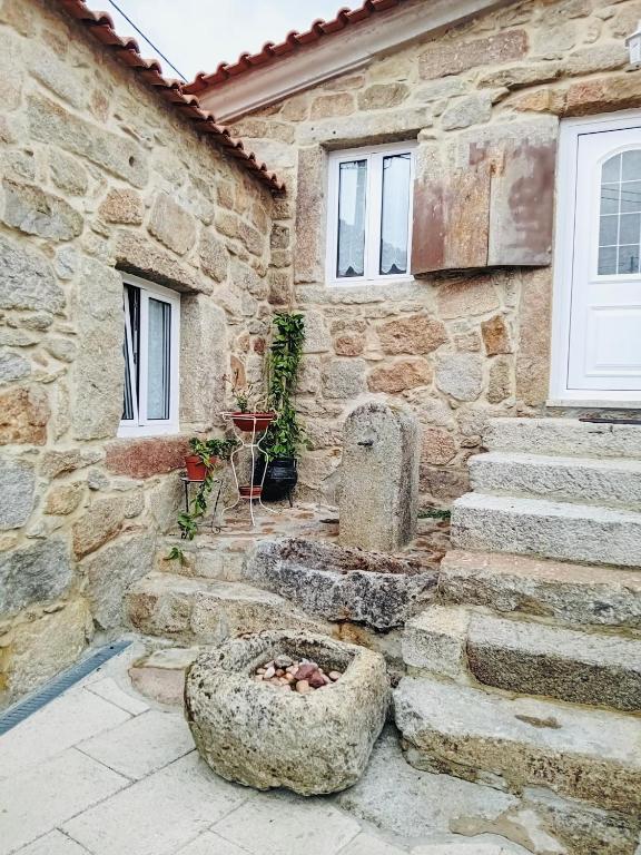 a stone building with a stone bowl in front of it at Casa do Regedor in Pinhel