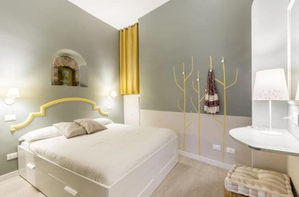 a bedroom with a white bed and a table at Trastevere Little Home in Rome