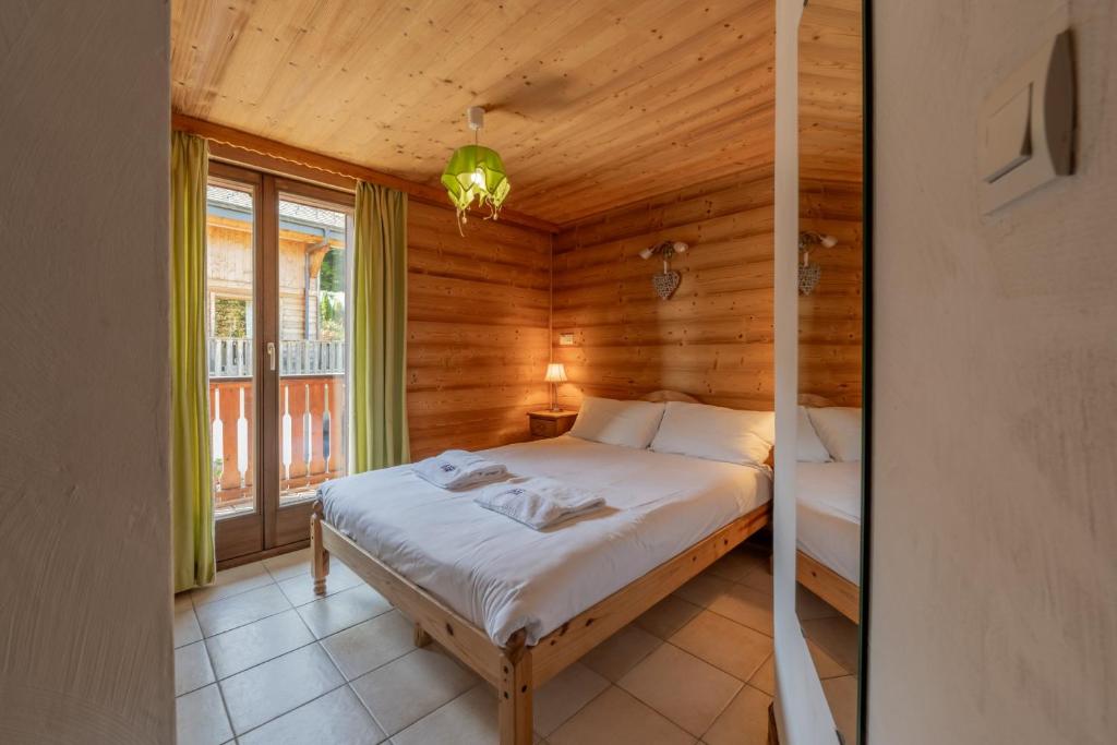 a bedroom with a bed in a wooden room at Clos Donne Apartment - Snow and Trek- Essert Romand in Essert-Romand