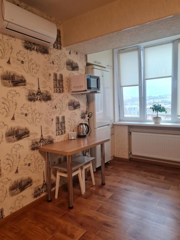 a kitchen with a wooden table in a room at Своя смарт квартира подобово Вокзальная in Kharkiv
