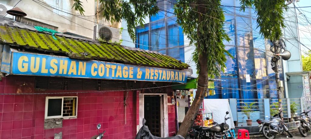 un bâtiment rose avec un panneau bleu dans l'établissement Gulshan Cottage, à Mussoorie