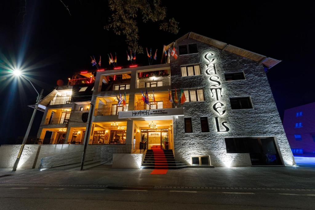 a building with a sign on it at night at Hotel Castel Suceava in Suceava