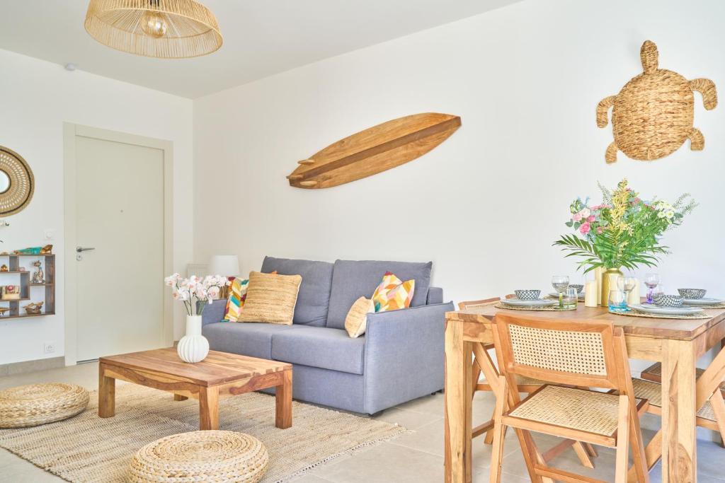 a living room with a blue couch and a table at Namasté - Idéal familles - Terrasse - Garage - Mer in Six-Fours-les-Plages