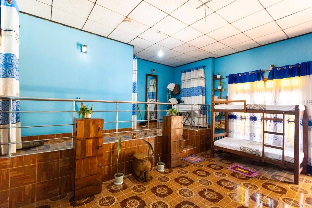 Un baño con paredes azules y un gato sentado en el centro. en The bunker Hostal - Ella Srilanka, en Ella