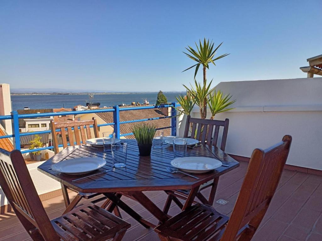 a wooden table on a balcony with a view of the ocean at T2 Moliceiros Torreira vista Ria in Torreira