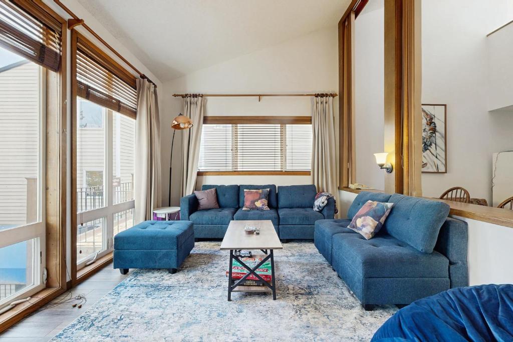 a living room with blue couches and a table at Mountainside 049 in Granby