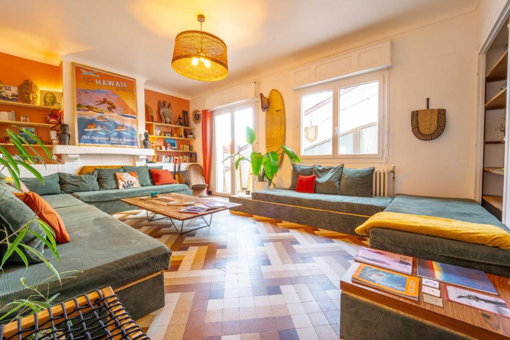 a living room with couches and a table at La Boga, un havre de paix en plein coeur de Biscarrosse Plage in Biscarrosse-Plage
