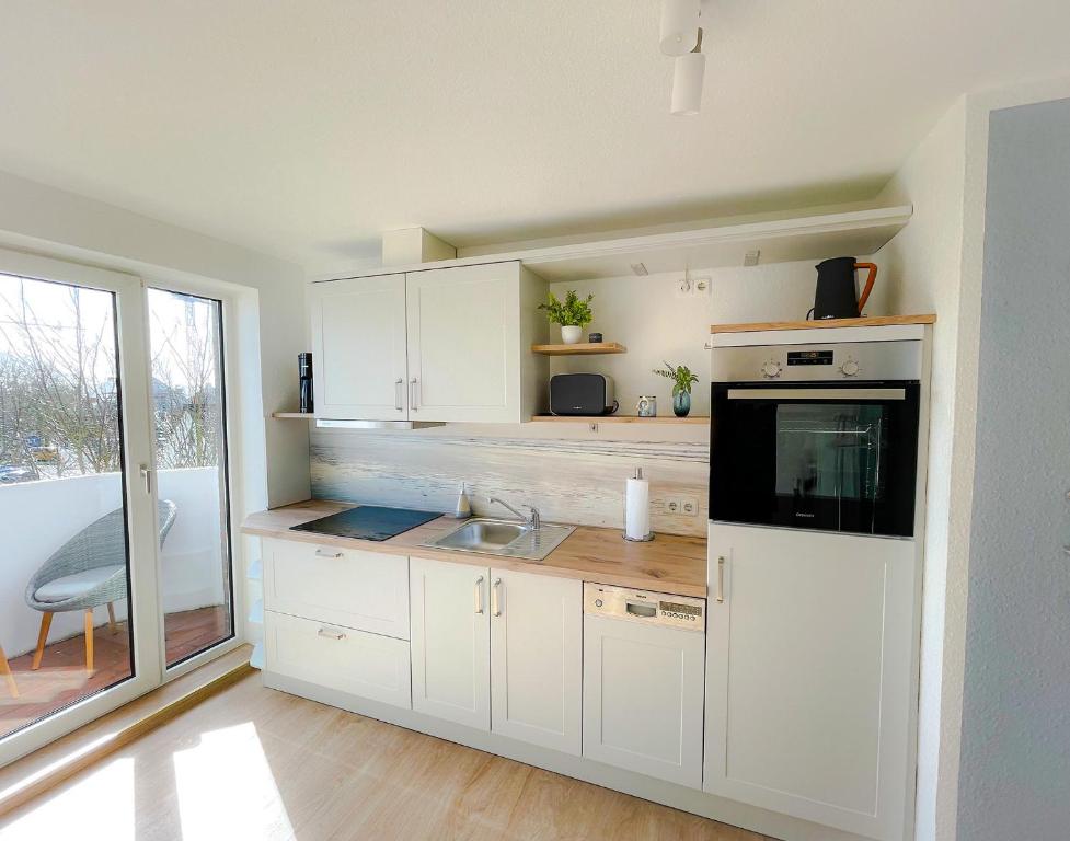 a kitchen with white cabinets and a sink at Seemöwe in Friedrichsschleuse