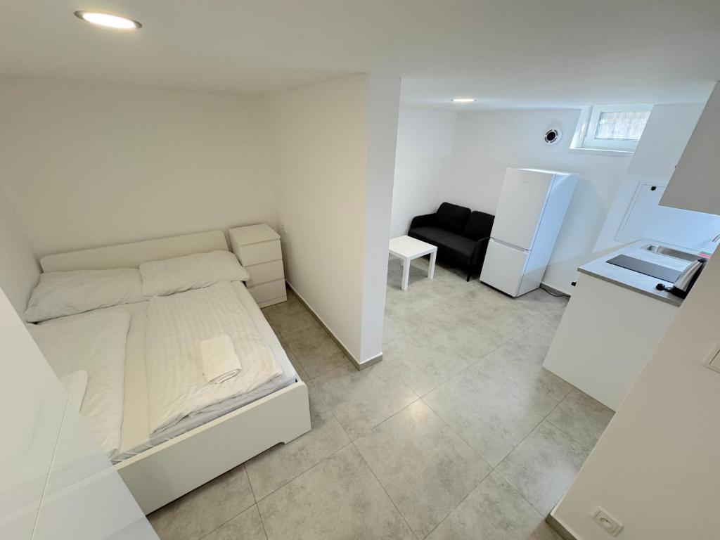 - une chambre blanche avec un lit et un canapé dans l'établissement Krásny byt - apartmán 6 v blízkosti centra, à Bratislava