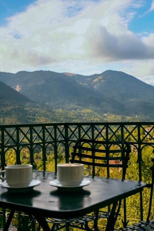 two coffee cups sitting on a table with a view at Αρχοντικό in Megalo Chorio